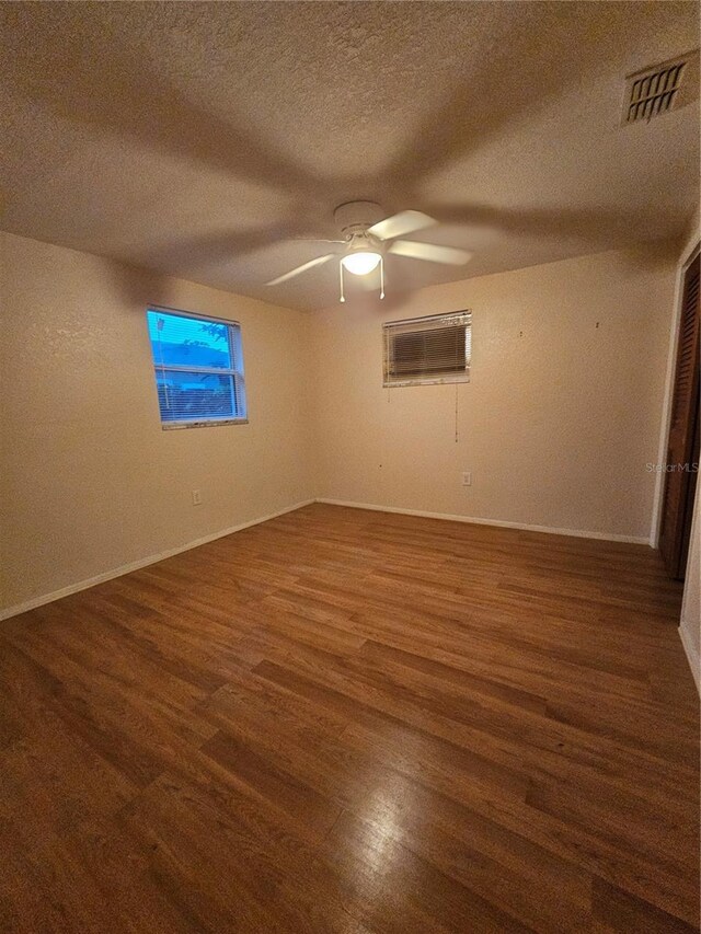 6339 Delaware Ave, New Port Richey, FL 34653 - unfurnished room with wood finished floors, a wall mounted air conditioner, a textured ceiling, and ceiling fan