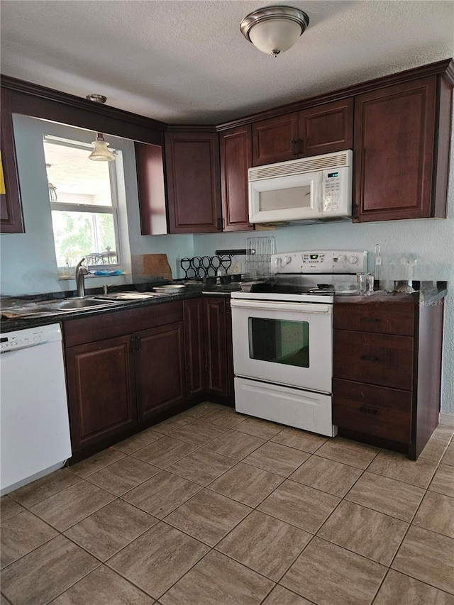 6339 Delaware Ave, New Port Richey, FL 34653 - kitchen with white appliances, dark countertops, dark brown cabinets, and a textured ceiling