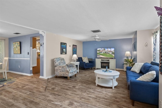 8021 Wildflower Row, Hudson, FL 34667 - living area with wood finished floors, baseboards, a ceiling fan, a textured ceiling, and healthy amount of natural light