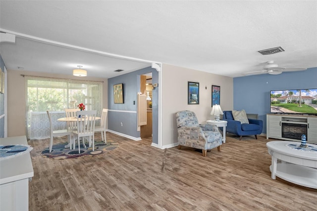 8021 Wildflower Row, Hudson, FL 34667 - living room with wood finished floors, baseboards, and a ceiling fan