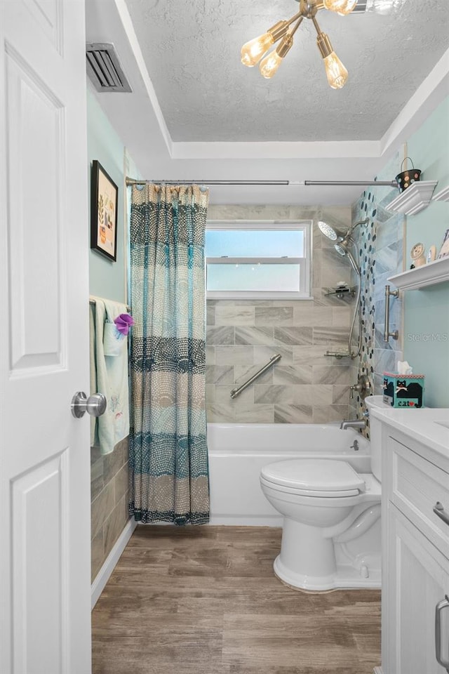 8021 Wildflower Row, Hudson, FL 34667 - bathroom featuring shower / bath combo with shower curtain, a textured ceiling, toilet, vanity, and wood finished floors