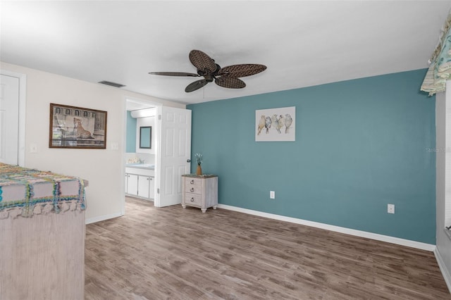 8021 Wildflower Row, Hudson, FL 34667 - unfurnished bedroom featuring wood finished floors, baseboards, a ceiling fan, and ensuite bathroom