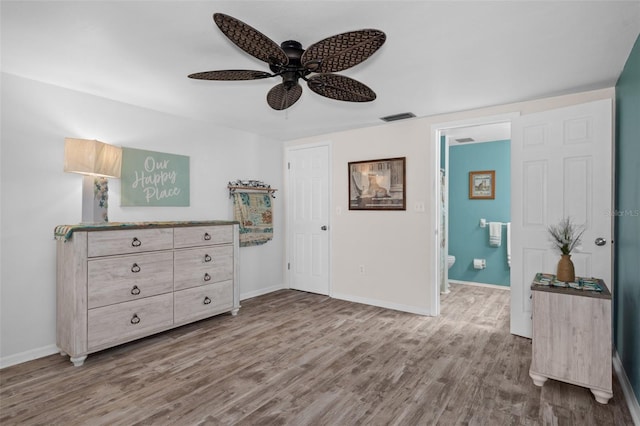 8021 Wildflower Row, Hudson, FL 34667 - bedroom featuring wood finished floors, baseboards, ceiling fan, and ensuite bath