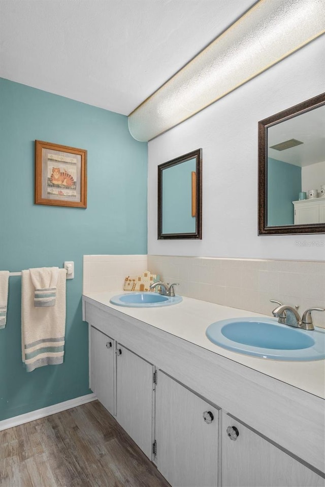 8021 Wildflower Row, Hudson, FL 34667 - full bathroom with wood finished floors, double vanity, and backsplash
