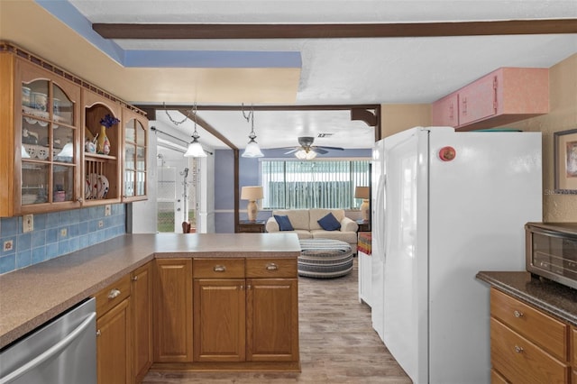 8021 Wildflower Row, Hudson, FL 34667 - kitchen featuring dishwasher, freestanding refrigerator, light wood-style flooring, ceiling fan, and a peninsula
