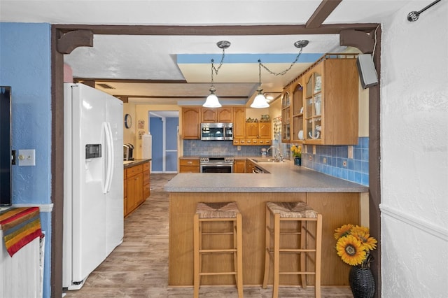 8021 Wildflower Row, Hudson, FL 34667 - kitchen with stainless steel appliances, backsplash, a peninsula, a sink, and glass insert cabinets