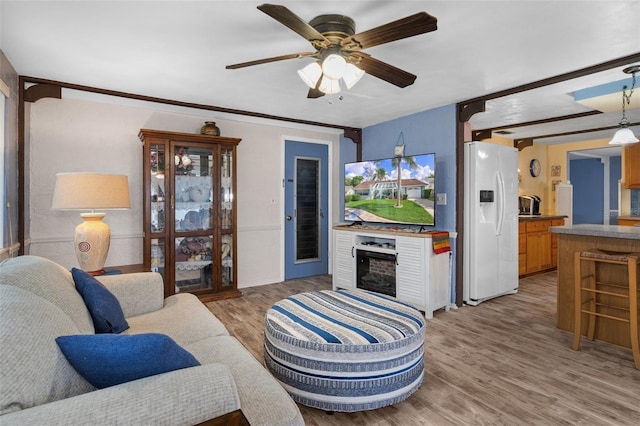 8021 Wildflower Row, Hudson, FL 34667 - living area featuring light wood-style flooring, a fireplace, and a ceiling fan