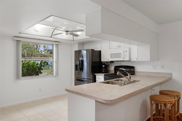 kitchen featuring white microwave, black / electric stove, a sink, stainless steel refrigerator with ice dispenser, and a ceiling fan