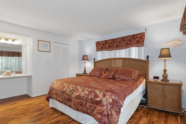 bedroom featuring wood finished floors, a closet, baseboards, and a textured ceiling