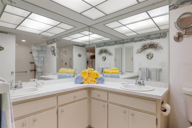 full bath featuring a shower with curtain, double vanity, and toilet