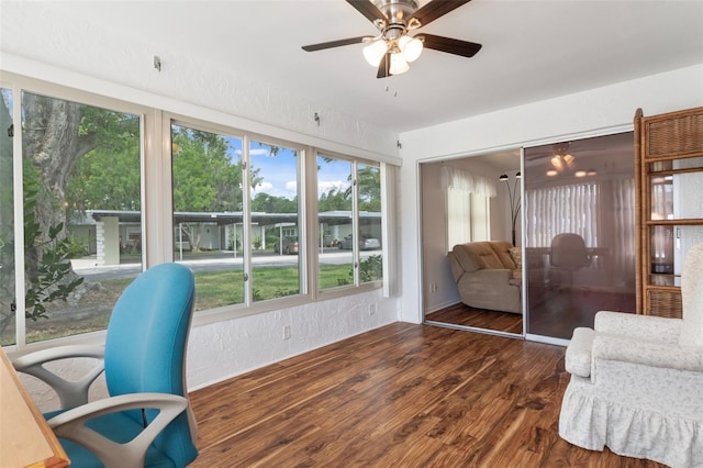 sunroom featuring a ceiling fan and wood finished floors