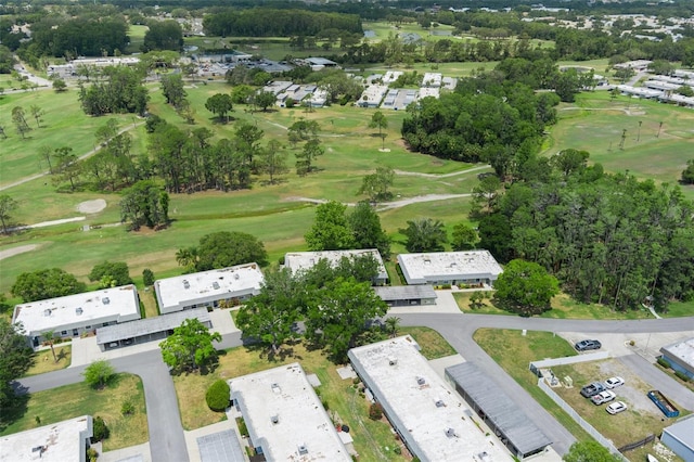 view of property location with a local golf course and a tree filled landscape