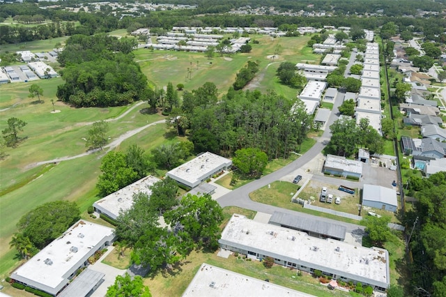 aerial view of property and surrounding area with a local golf course and nearby suburban area