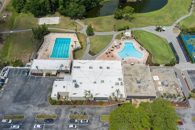 aerial overview of property's location featuring a pool area, a nearby body of water, and a golf course
