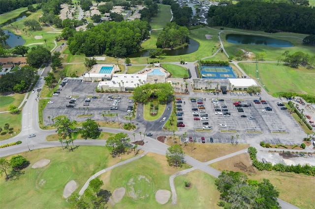 aerial view of property and surrounding area with a nearby body of water and a golf club