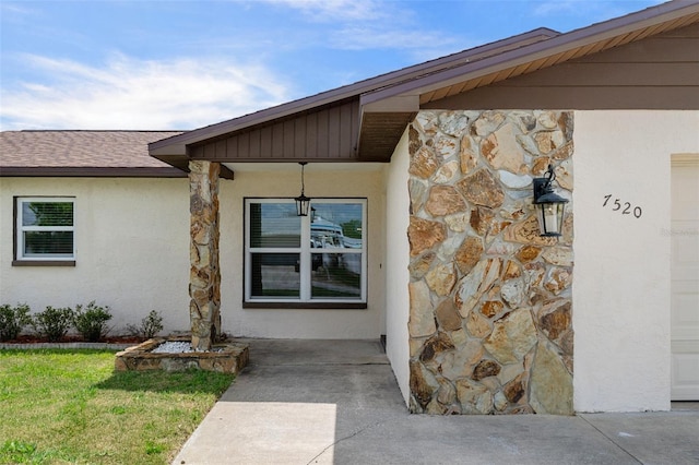 7520 Mako Dr, Hudson, FL 34667 - view of exterior entry featuring stone siding, stucco siding, and a lawn
