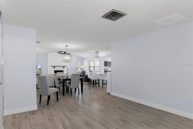 7520 Mako Dr, Hudson, FL 34667 - dining area with light wood finished floors, baseboards, and a chandelier