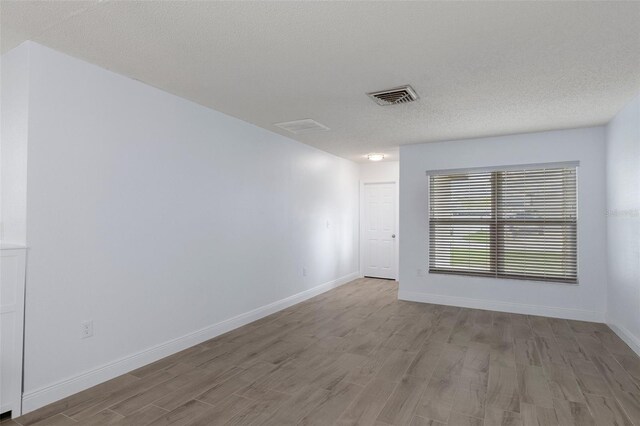7520 Mako Dr, Hudson, FL 34667 - spare room with wood finished floors, baseboards, and a textured ceiling