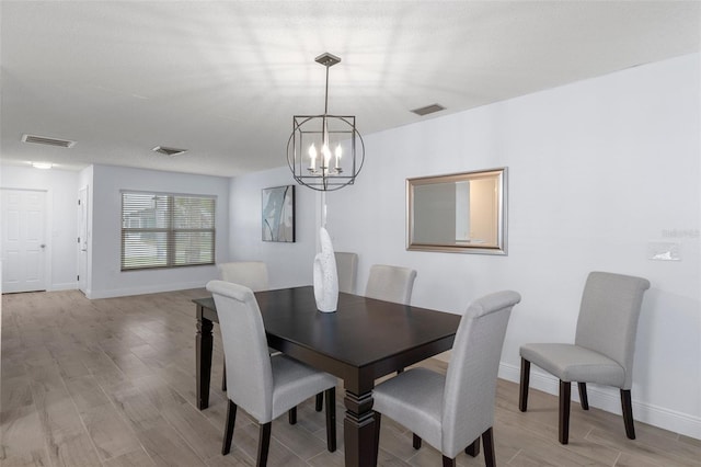 7520 Mako Dr, Hudson, FL 34667 - dining room with a chandelier, light wood finished floors, and baseboards