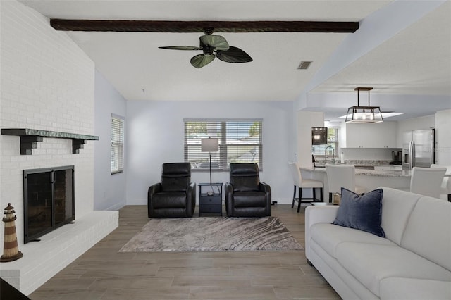 7520 Mako Dr, Hudson, FL 34667 - living room featuring a ceiling fan, wood finished floors, a fireplace, and baseboards