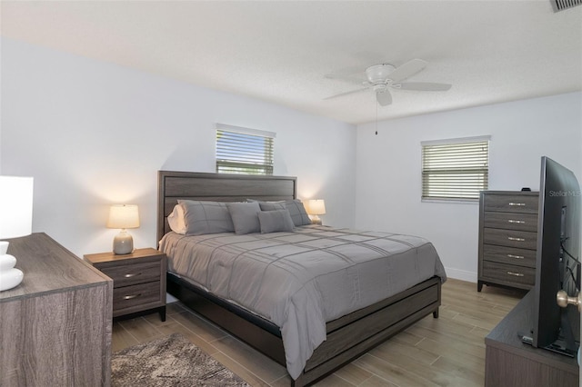 7520 Mako Dr, Hudson, FL 34667 - bedroom with wood tiled floors, multiple windows, a ceiling fan, and baseboards