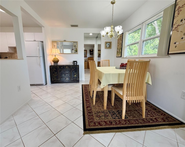 11631 Bayonet Ln, New Port Richey, FL 34654 - dining area featuring a chandelier, baseboards, and light tile patterned floors