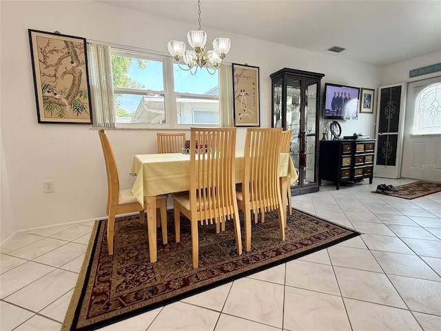 11631 Bayonet Ln, New Port Richey, FL 34654 - dining area featuring a chandelier, plenty of natural light, tile patterned floors, and baseboards