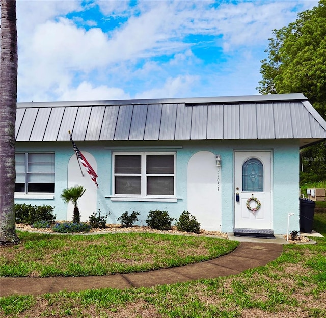 11631 Bayonet Ln, New Port Richey, FL 34654 - view of front of house featuring stucco siding, a front yard, and metal roof