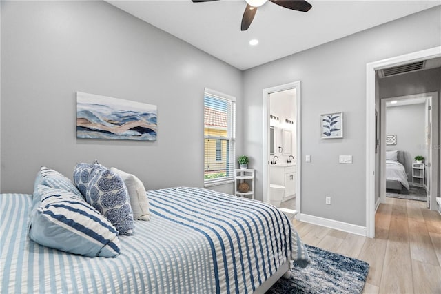 bedroom featuring light wood-style flooring, baseboards, ensuite bath, recessed lighting, and a ceiling fan