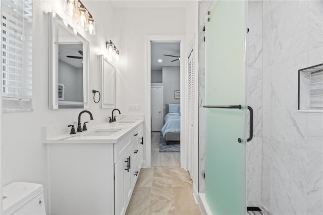 bathroom featuring ceiling fan, a stall shower, toilet, double vanity, and marble finish flooring