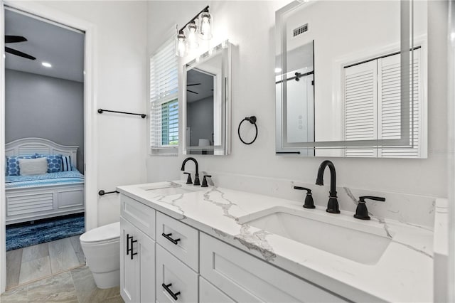 bathroom with ensuite bathroom, toilet, and double vanity