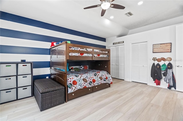 bedroom with wood finished floors, recessed lighting, two closets, and a ceiling fan