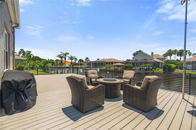 wooden terrace featuring area for grilling, a water view, and a residential view