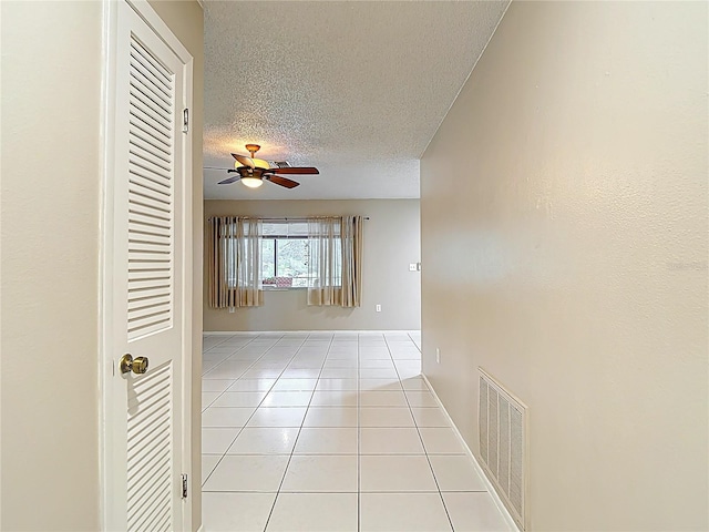 13003 Sandburst Ln, Hudson, FL 34667 - corridor featuring tile patterned flooring, a textured ceiling, and baseboards