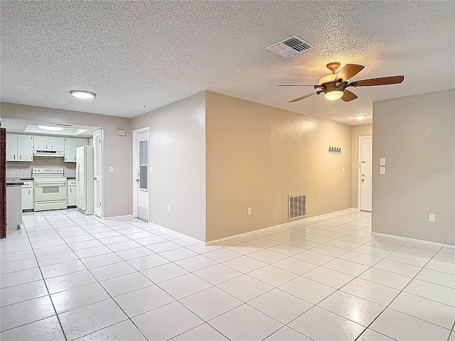13003 Sandburst Ln, Hudson, FL 34667 - unfurnished living room featuring ceiling fan, a textured ceiling, light tile patterned floors, and baseboards