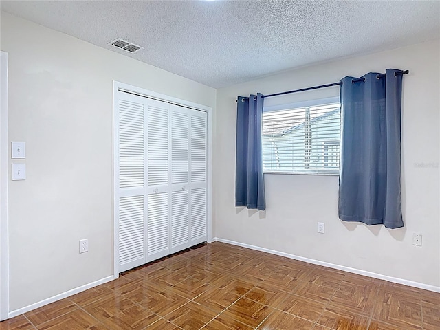 13003 Sandburst Ln, Hudson, FL 34667 - unfurnished bedroom with baseboards, a closet, and a textured ceiling