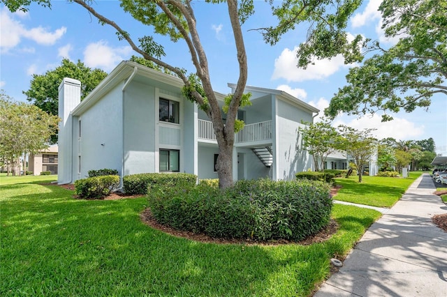 306 Martha Ln Unit 42, Oldsmar, FL 34677 - view of side of home with a chimney, a lawn, and stucco siding