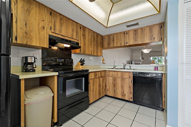 306 Martha Ln Unit 42, Oldsmar, FL 34677 - kitchen with black appliances, under cabinet range hood, a sink, and light countertops
