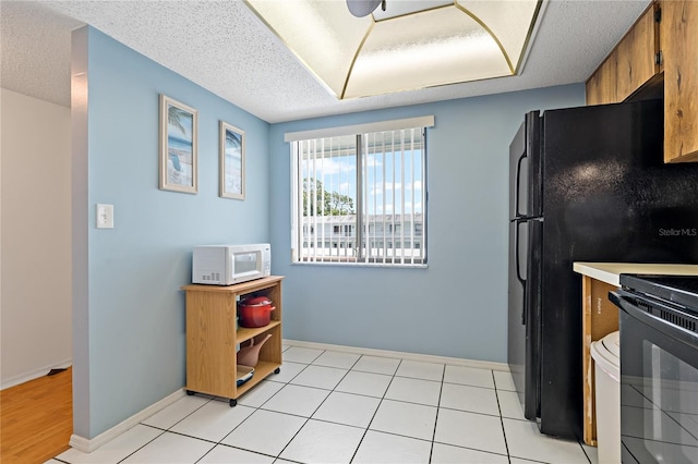 306 Martha Ln Unit 42, Oldsmar, FL 34677 - kitchen with white microwave, range, baseboards, brown cabinetry, and light countertops