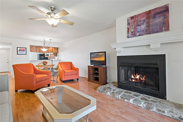 306 Martha Ln Unit 42, Oldsmar, FL 34677 - living area featuring wood finished floors, a warm lit fireplace, and ceiling fan