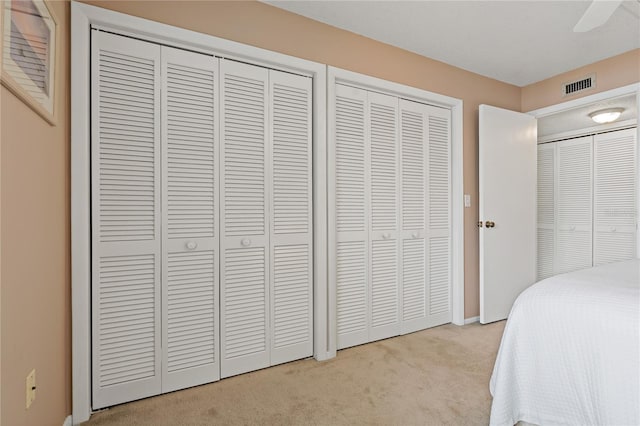 306 Martha Ln Unit 42, Oldsmar, FL 34677 - carpeted bedroom with baseboards, two closets, and a ceiling fan
