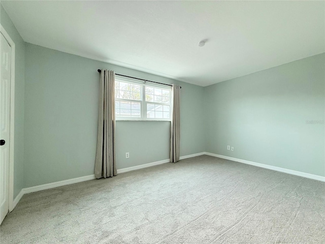 empty room featuring carpet floors and baseboards