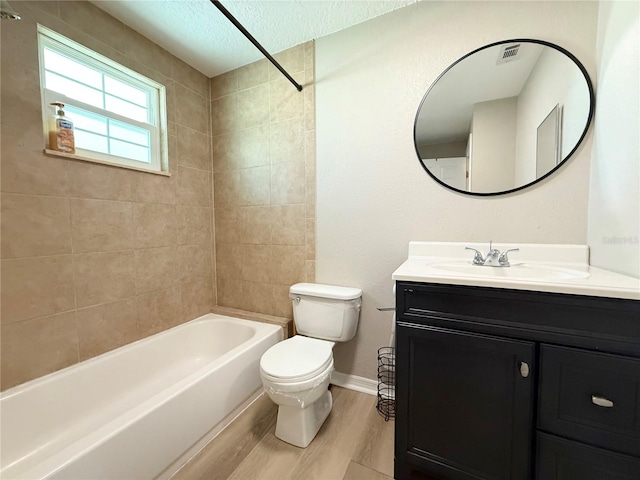 bathroom featuring wood finished floors, toilet, baseboards, shower / bathtub combination, and vanity