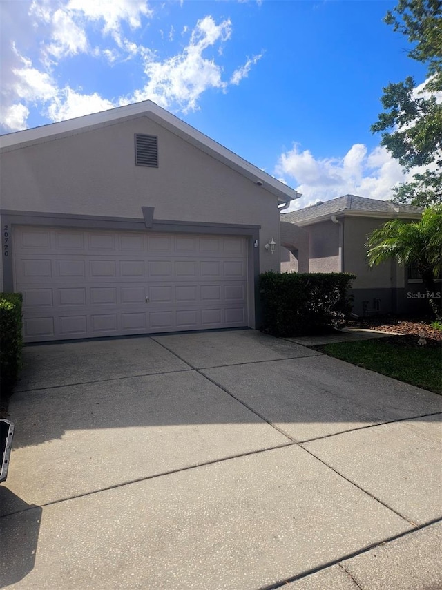 20720 Eustis Rd, Land O Lakes, FL 34637 - view of front facade featuring stucco siding, concrete driveway, and an attached garage