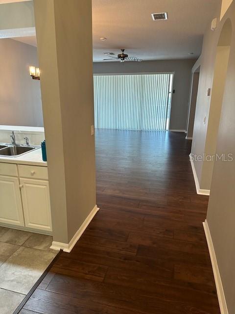 20720 Eustis Rd, Land O Lakes, FL 34637 - corridor featuring a sink, wood finished floors, baseboards, and arched walkways