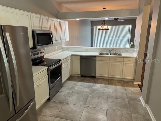 20720 Eustis Rd, Land O Lakes, FL 34637 - kitchen with appliances with stainless steel finishes, a sink, a chandelier, light countertops, and pendant lighting