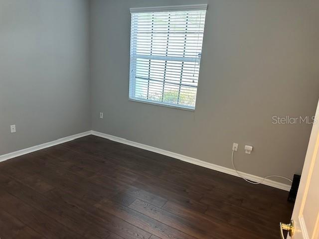 20720 Eustis Rd, Land O Lakes, FL 34637 - empty room featuring baseboards and dark wood finished floors