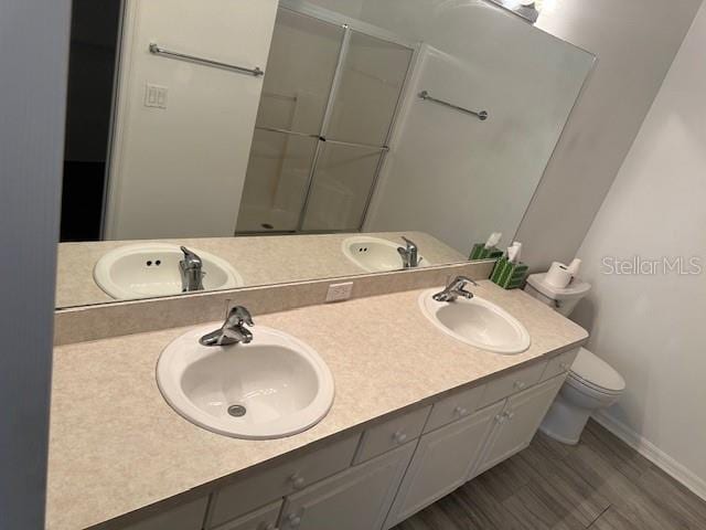 20720 Eustis Rd, Land O Lakes, FL 34637 - bathroom with a stall shower, toilet, baseboards, and double vanity