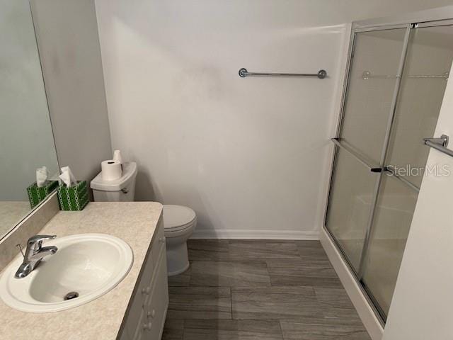 20720 Eustis Rd, Land O Lakes, FL 34637 - bathroom featuring toilet, a shower stall, vanity, and baseboards