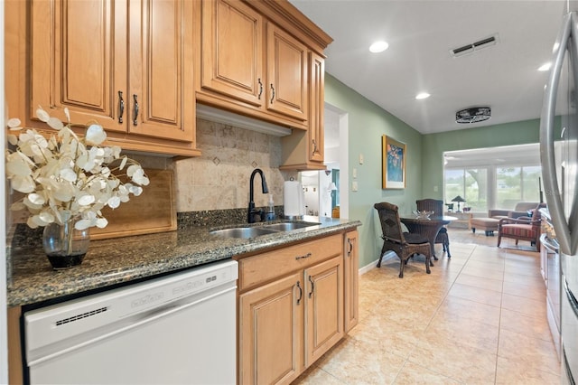 7512 Heather Walk Dr, Weeki Wachee, FL 34613 - kitchen featuring white dishwasher, decorative backsplash, light tile patterned flooring, dark stone countertops, and recessed lighting